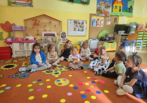 Dzieci siedzą na dywanie