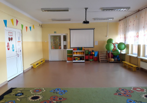 Sala zajęć ruchowych. W rogu zielone duże piłki.