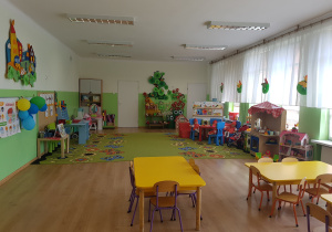Sala Jagódki z żółtymi stolikami i zielonym dywanem