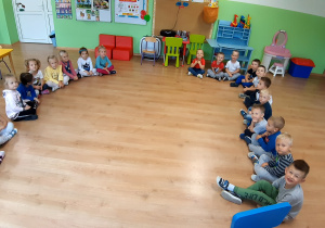 Dzieci siedzące w półkole, podczas pojedynku chłopaki kontra dziewczyny w śpiewaniu piosenki "Jagódki"