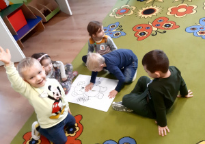 Dzieci układają obrazek z misiem podzielony na cztery części