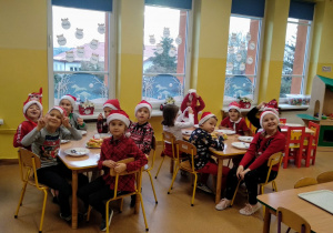 Dzieci podczas śniadania w Mikołajowych czapkach
