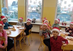 Dzieci podczas śniadania w Mikołajowych czapkach