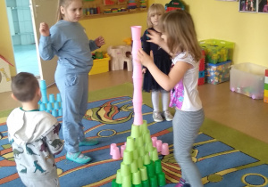 Dzieci budują wieżę z kolorowych kubków