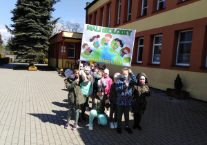Dzieci z transparentem przed przedszkolem