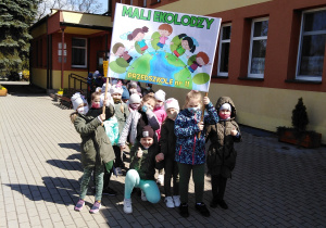 Dzieci z transparentem przed przedszkolem