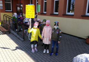 Dzieci z plakatami przed przedszkolem