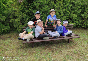 Chłopcy na ławce w ogrodzie pozują do zdjęcia