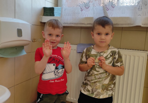 Chłopcy pokazują umyte ręce