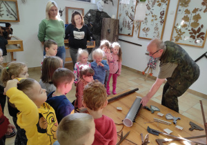 Dzieci podczas zwiedzania izby edukacyjnej z panem leśniczym