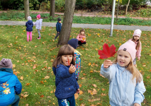 Dzieci zbierają jesienne liście w parku