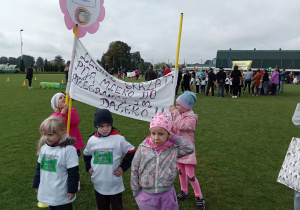 Dzieci z transparentem stoją na boisku szkolnym
