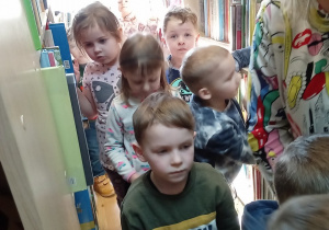 Dzieci oglądają książki znajdujące się na półkach