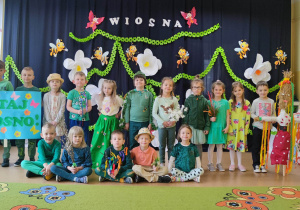 Dzieci z grupy Poziomki na tle dekoracji wiosennej