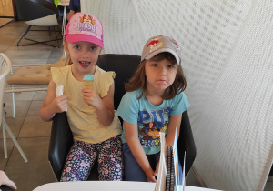 Dzieci w lodziarni jedzą lody