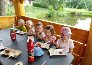 Dzieci podczas jedzenia kiełbasek