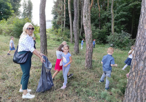 Dzieci w lesie podczas sprzątania śmieci