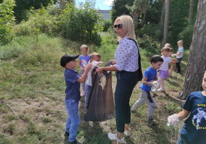 Dzieci w lesie podczas sprzątania śmieci