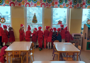 Dzieci wyglądają przez okno w oczekiwaniu na św. Mikołaja