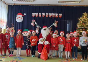 Dzieci ze św. Mikołajem pozują do zdjęcia grupowego