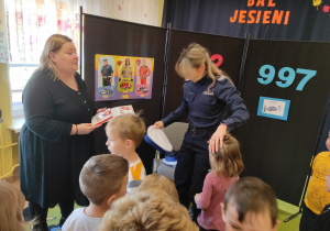 Nauczycielka wręcza podziękowanie Pani policjantce