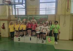 Dzieci z grupy poziomki stoją na podium 3 miejsca.