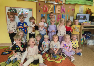 Dzieci z grupy Muchomorki pozują do zdjęcia grupowego na tle dekoracji
