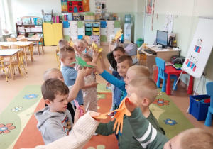 Dzieci witają się kolorowymi "łapkami" i mówią sobie miłe słowa