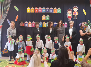 Dzieci stoją na tle dekoracji i pozują do zdjęcia grupowego