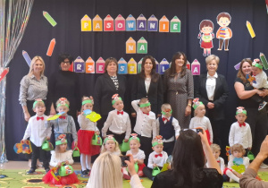 Dzieci stoją na tle dekoracji i pozują do zdjęcia grupowego