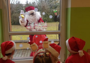 Mikołaj zagląda przez okno do dzieci