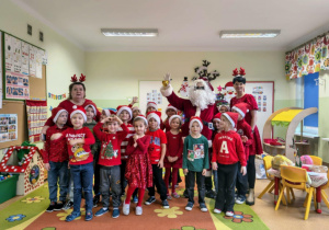 Dzieci pozują do zdjęcia ze Świętym Mikołajem