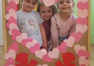 Dzieci pozują w okienku z serduszek