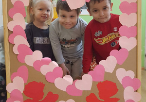 Dzieci pozują w okienku z serduszek