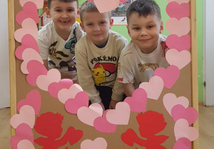 Dzieci pozują w okienku z serduszek