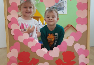 Dzieci pozują w okienku z serduszek