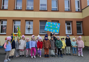 Grupa dzieci pozuje do zdjęcia przed budynkiem przedszkola