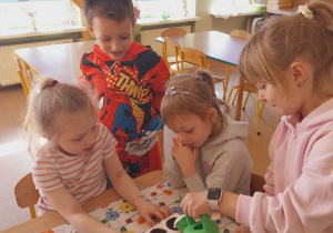 Dzieci wsypują ziemię do foremek