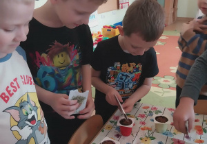 Dzieci wsypują nasionka rzeżuchy