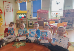 Dzieci prezentują plakaty o bezpieczeństwie w sieci