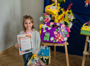 Laureatka konkursu stoi z dyplomem i nagrodą