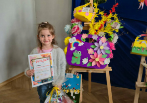 Laureatka I miejsca z dyplomem i nagrodą pozuje do zdjęcia