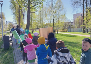 dzieci idą z transparentami po parku