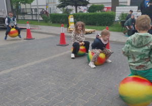 dzieci skaczą na kolorowych piłkach