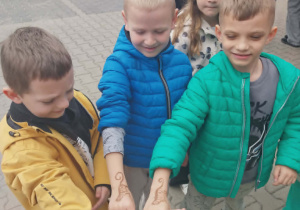 chłopcy pokazują namalowane zwierzątka