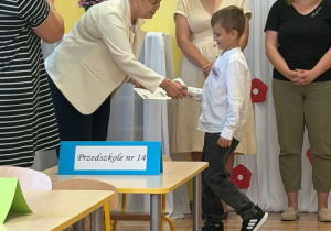 chłopiec przyjmuje gratulacje