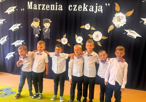 chłopcy z grupy "Biedronki" pozują w strojach galowych i biretach