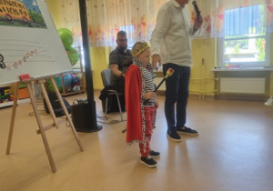 Chłopiec stoi na scenie przebrany za króla