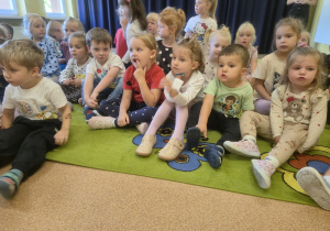 Dzieci siedzą na dywanie