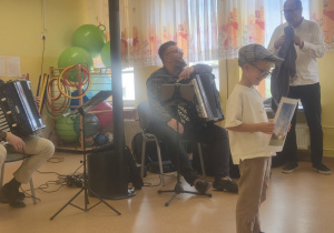 Chłopiec z muzykami występuje na scenie